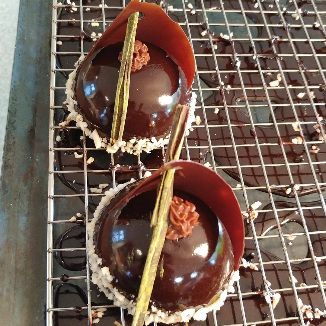 Two mirror-glazed chocolate entremets on a cooling rack