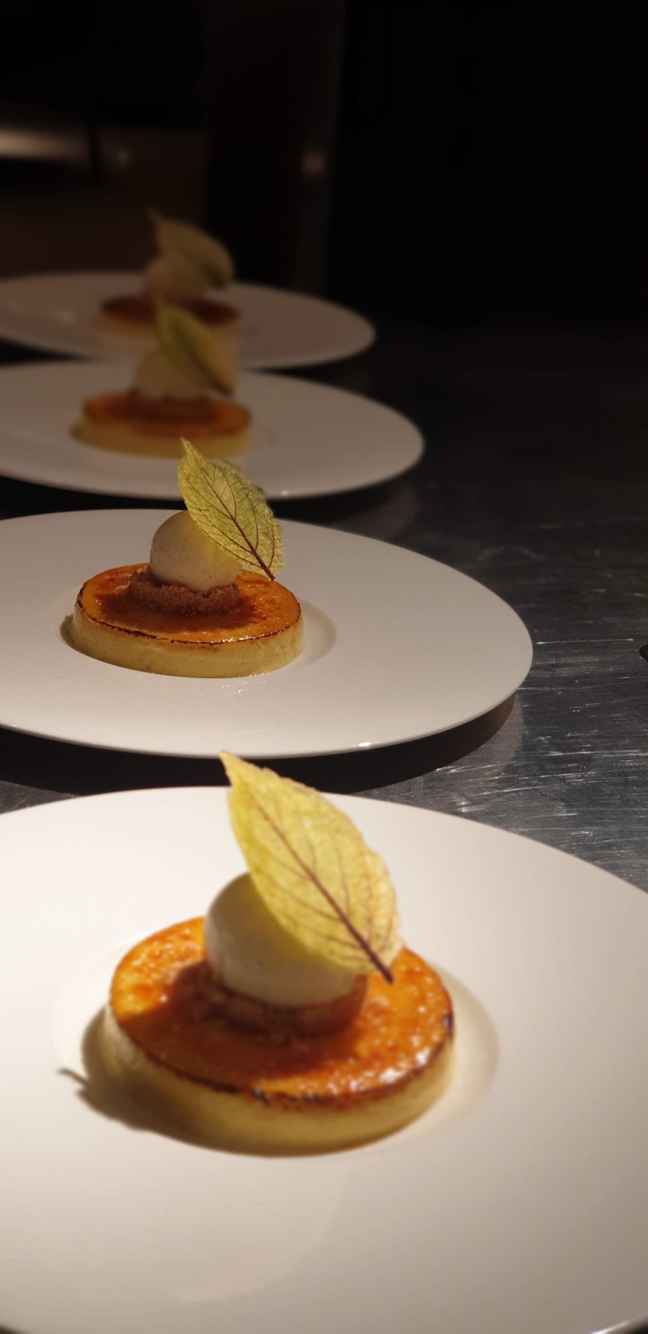 A line of dessert plates along a stainless steel galley pass